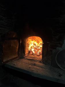 un horno de ladrillo con un fuego dentro de él en Cerdeira - Home for Creativity, en Lousã
