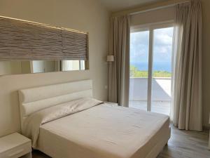 a bedroom with a bed and a large window at Borgo San Cosmo Tropea in Brattirò