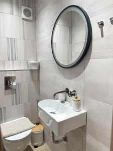 een badkamer met een witte wastafel en een spiegel bij Apartment in the center of Agia Sophia in Thessaloniki