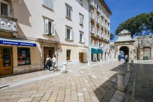 a cobblestone street in a city with buildings at Apartments Jadera in Zadar