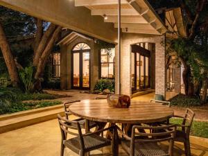 a wooden table and chairs in a courtyard at Mbano Manor Hotel Victoria Falls by Mantis in Victoria Falls