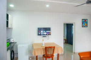 ein Esszimmer mit einem Tisch und einem TV an der Wand in der Unterkunft 509 Résidence in Lomé