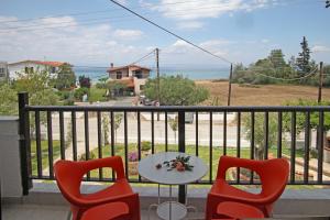 a table and chairs on a balcony with a view of the ocean at Villa Alexandra Suites in Polychrono
