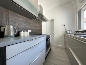 a kitchen with white counters and a stove top oven at 4 bed house off Norton village in Stockton-on-Tees