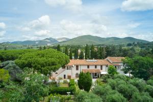 a house in a garden with mountains in the background at Antichi Palmenti - Erica in San Vincenzo