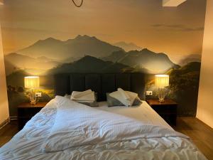 a bedroom with a large bed with a mountain mural on the wall at Hotel Neda Galichnik in Galičnik