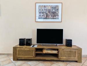 een televisie op een houten entertainmentcentrum met twee luidsprekers bij Ferienwohnungen Schallenberg - Gross-Umstadt in Groß-Umstadt