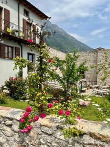 a house with flowers in front of a stone wall at Villa del Lis in Gargnano
