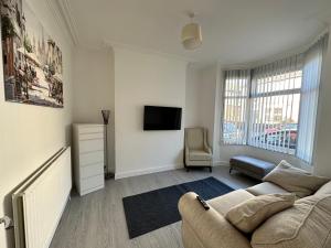 een woonkamer met een bank en een tv bij 4 bed house off Norton village in Stockton-on-Tees