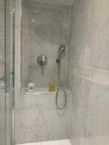 une douche avec pommeau de douche dans une salle de bain dans l'établissement L’élégance du prado, à Marseille 11 autres photos