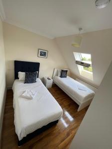 a small bedroom with two beds and a couch at RC Airport Rooms in Stanwell