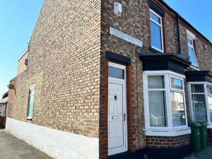 een bakstenen gebouw met een witte deur en ramen bij 4 bed house off Norton village in Stockton-on-Tees