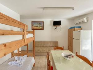 Zimmer mit einem Etagenbett, einem Tisch und einem Kühlschrank in der Unterkunft Amazona Apartments and Studios in Sparta