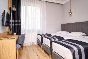 a hotel room with two beds and a desk at Buyuk Truva Hotel in Canakkale