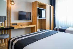 a hotel room with a bed and a tv at Buyuk Truva Hotel in Canakkale