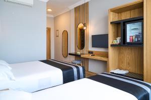 a hotel room with two beds and a tv at Buyuk Truva Hotel in Canakkale