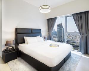 sypialnia z dużym łóżkiem i dużym oknem w obiekcie Nasma Luxury Stays - Central Park Tower w Dubaju