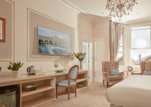 um quarto de hotel com uma cama, uma secretária e uma televisão em Bathen House Boutique Hotel em Bath