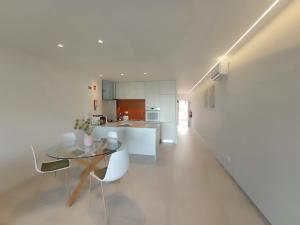 een keuken met een glazen tafel en witte stoelen bij Apartment Yulya in Albufeira