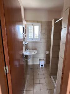 a small bathroom with a sink and a toilet at Michael’s Vacancies in Fánai +94 photos