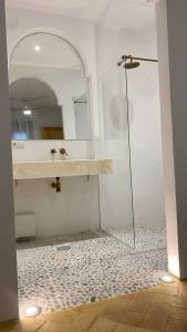 y baño con ducha acristalada y lavamanos. en Doñana Suite Casa-Hotel en El Rocío