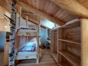 Cette grande chambre en bois comprend 2 lits superposés. dans l'établissement Agriturismo Malga Pontevecchio, à Cogolo