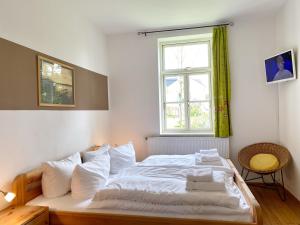 - une chambre avec un lit doté de draps blancs et une fenêtre dans l'établissement Ferienwohnung am Nationalpark, à Sassnitz