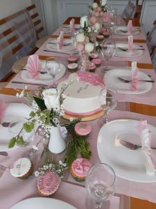 a table with pink and white plates and wine glasses at Vila Oaza - Zvorničko jezero in Zvornik