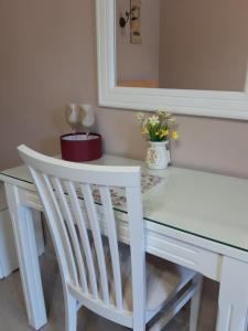 a white dining table with a white chair and a mirror at Vila Oaza - Zvorničko jezero in Zvornik