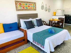 a bedroom with two beds and a table with a kitchen at Flet vista mar 1 in Arraial do Cabo