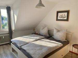 een slaapkamer met 2 bedden en een raam bij Feriendomizil Mühlenblick in Xanten