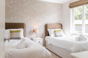1 dormitorio con 2 camas y ventana en Heathland Lodge - Norfolk Cottage Agency, en Kelling