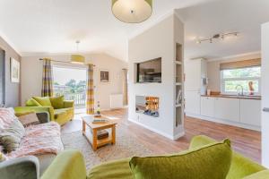 sala de estar con sofá y mesa en Heathland Lodge - Norfolk Cottage Agency, en Kelling
