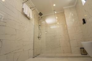 a bathroom with a shower with white marble tiles at Newarise Hotel in Rize