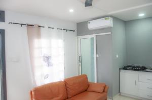an orange couch in a living room with a window at 509 Résidence in Lomé