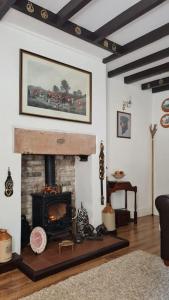 Peaceful cottage retreat in the Peak District في Wirksworth: غرفة معيشة مع موقد في غرفة