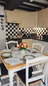 a kitchen with a table with plates and flowers on it at Peaceful cottage retreat in the Peak District in Wirksworth