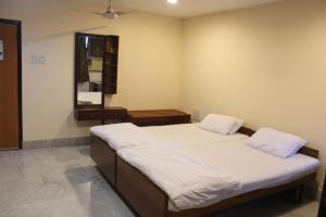 a bedroom with two beds and a mirror at Service Apartments, Park Street, Calcutta in Kolkata