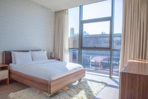 a bedroom with a bed and a large window at Nasma Luxury Stays - City Walk Building 5 in Dubai