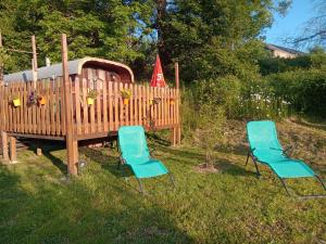twee blauwe stoelen in het gras naast een speeltuin bij La tiote roulotte in Marquigny