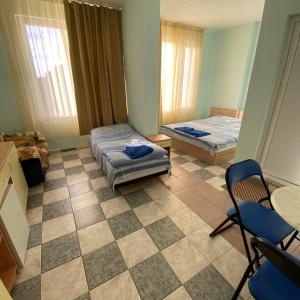 a room with two beds and a table and chairs at Hostel Shabla in Shabla