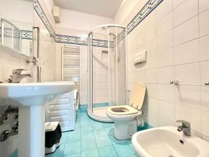 y baño con aseo, lavabo y ducha. en Venere Apartament, en Tirrenia