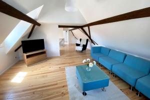 een woonkamer met een blauwe bank en een tv bij Nice Apartment in Eschborn in Eschborn
