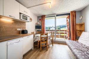 a kitchen and dining room with a table with a view at Les Pralyssimes in Taninges