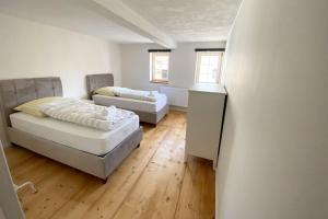 een kamer met 2 bedden, een tafel en 2 ramen bij Nice Apartment in Eschborn in Eschborn
