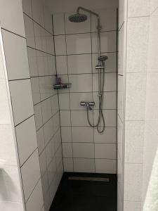 a shower in a bathroom with white tiles at Rooms Aida in Pula