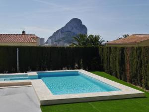 ein Schwimmbad in einem Garten mit einem Berg im Hintergrund in der Unterkunft Llar Soraya - Chalet en Calpe in Calpe