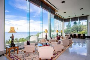 a living room with a large glass wall at Royal Wing Suites & Spa Pattaya in Pattaya South