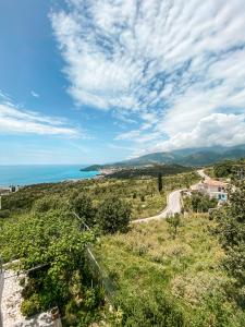 a road on a hill with a view of the ocean at ELÉA Guesthouse himare in Himare