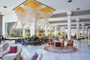 een grote lobby met witte meubels en een grote kroonluchter bij Royal Wing Suites & Spa Pattaya in Pattaya South